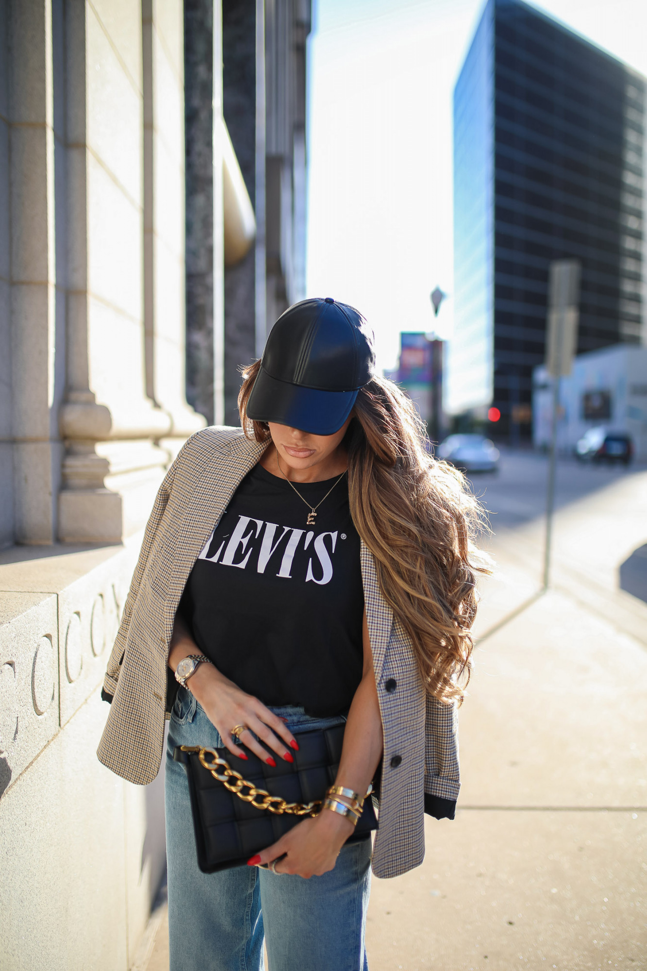 walmart fashion outfit ideas fall 2021, cute walmart outfit inspo fall, emiily gemma, tulsa fashion blogger, oversized plaid boyfriend blazer-10 | Fall Street Style by popular US fashion blog, The Sweetest Thing: image of Emily Gemma outside in a city and wearing black faux leather baseball hat, plaid jacket, leaves graphic t-shirt, rolled hem jeans, and tan stiletto heel sandals. 