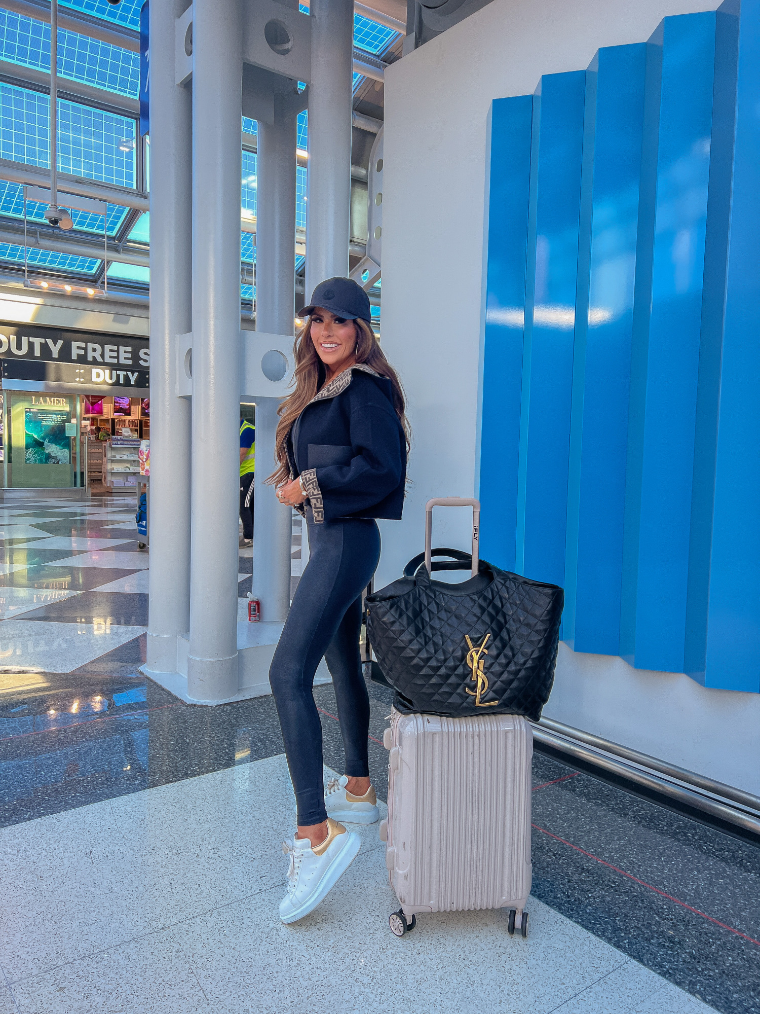 fendi reversible jacket, YSL icare maxi tote, what to wear and pack on overnight flight to europe, moncler ball cap, casual stylish airport outfit idea pinterest