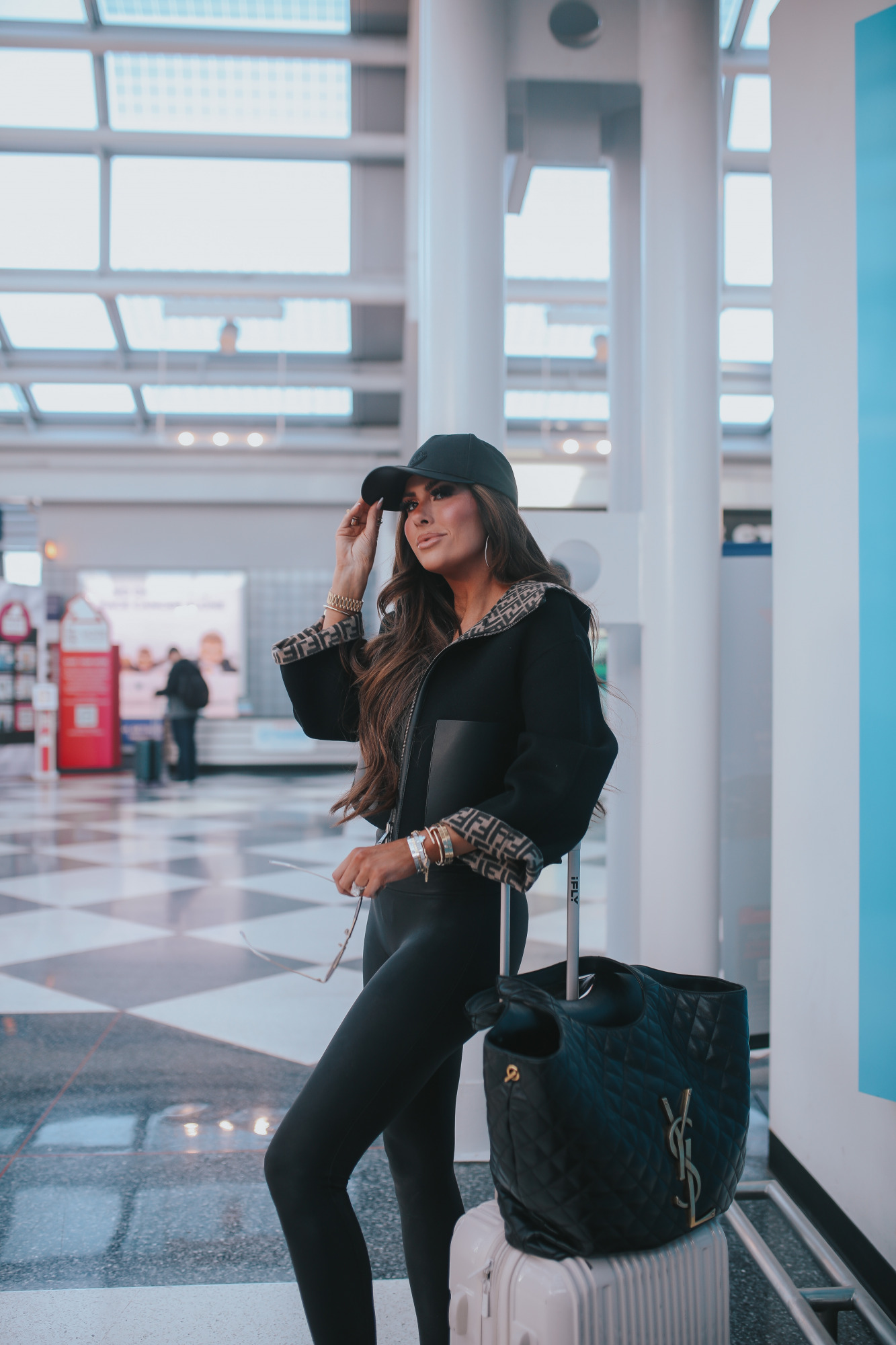 https://www.thesweetestthingblog.com/wp-content/uploads/2022/11/spanx-leggings-outfit-idea-what-to-wear-and-pack-on-overnight-flight-to-europe-fendi-reversible-jacket-moncler-ball-cap.jpg